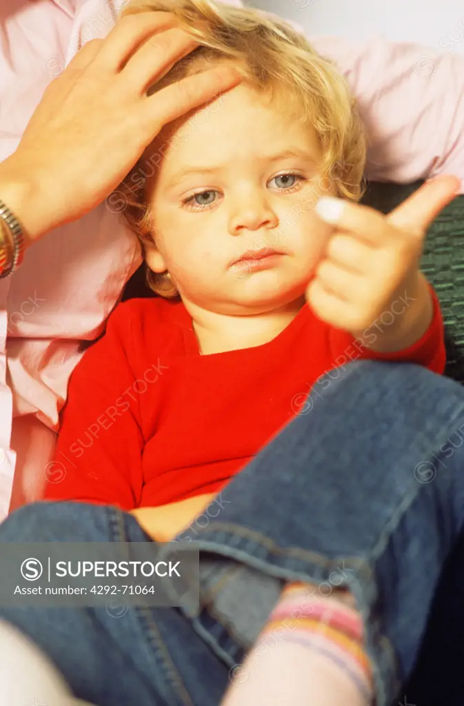 Little girl looking at plaster on her finger
