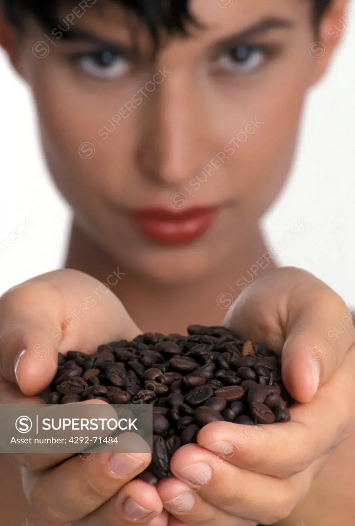 Portrait of a woman showing coffee beans