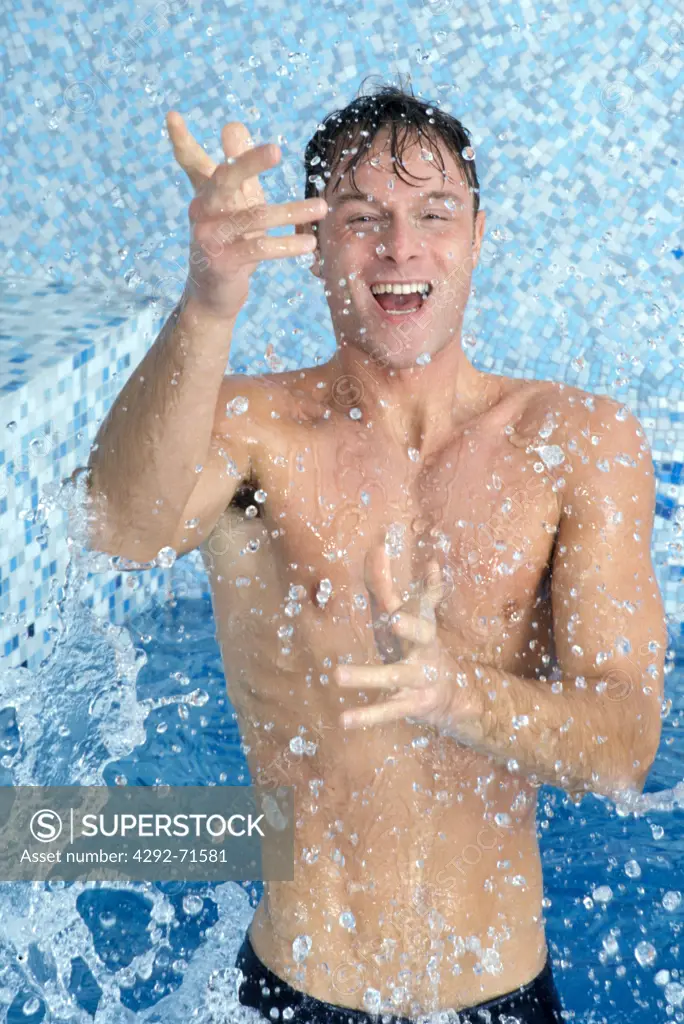 Man splashing water on himself at swimming pool