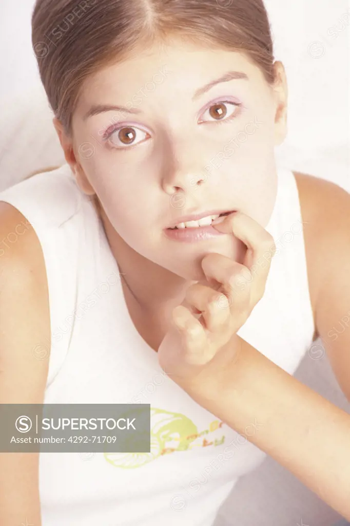 Teenage girl with finger in mouth