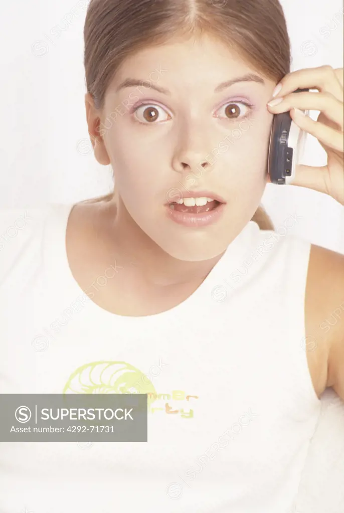 Teenage girl on mobile with surprised face