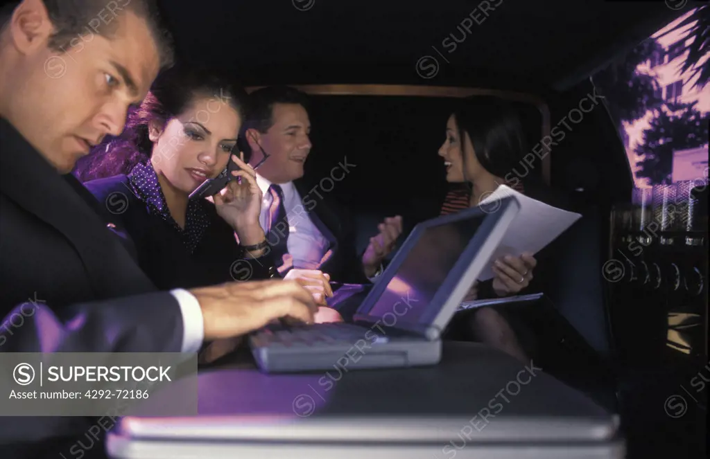 Businessmen and women working while on a car