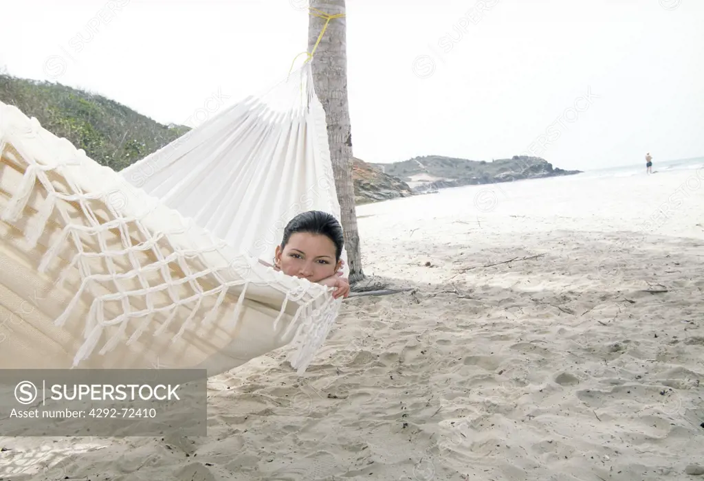 Portrait of a woman in hammock on beach