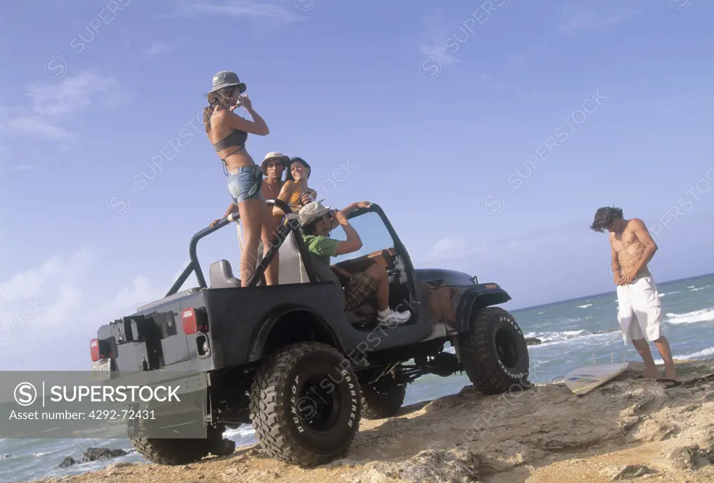Friends in stationary off road vehicle on the beach