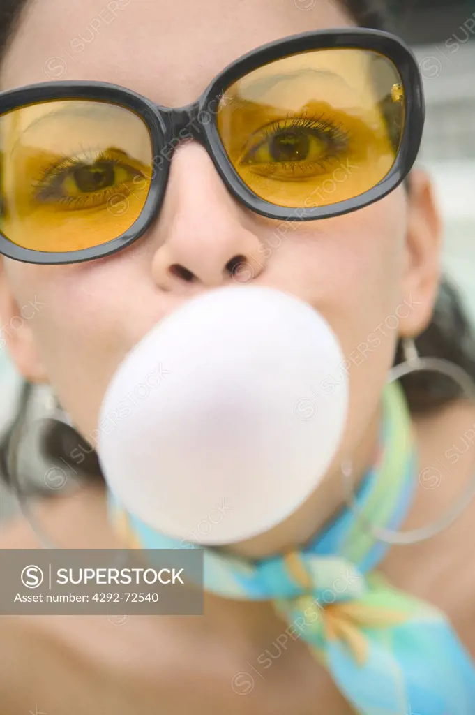 Woman's close up blowing gum