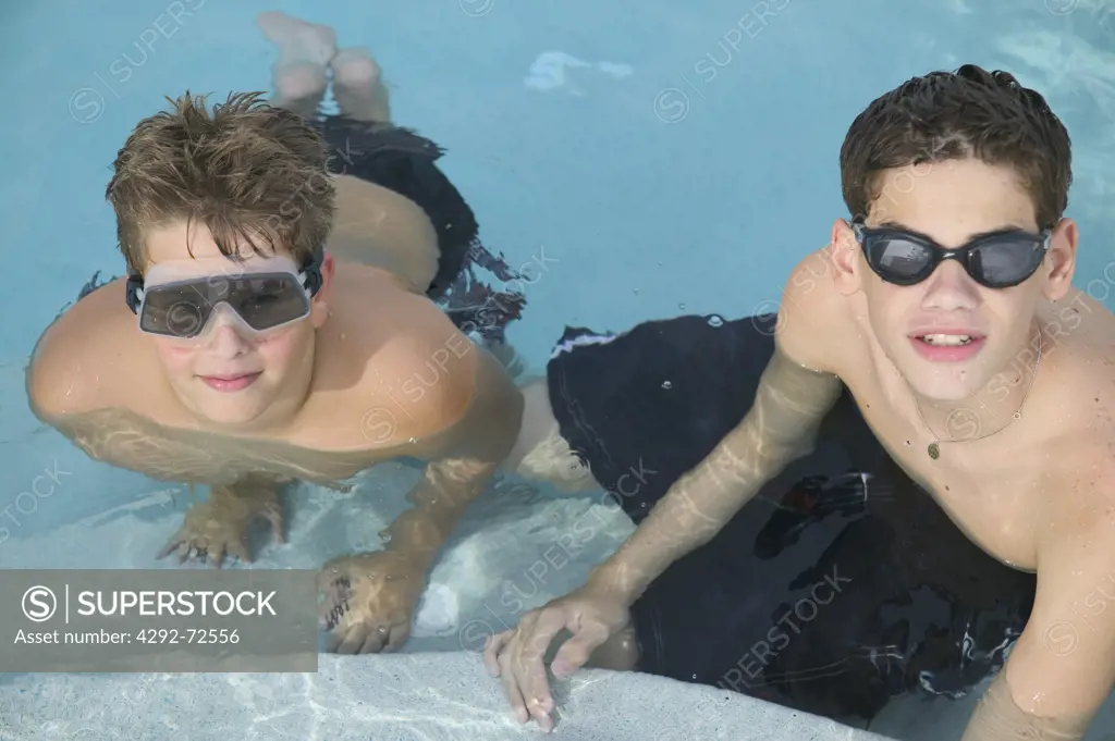 Two boys with swimm goggles in swimming pool