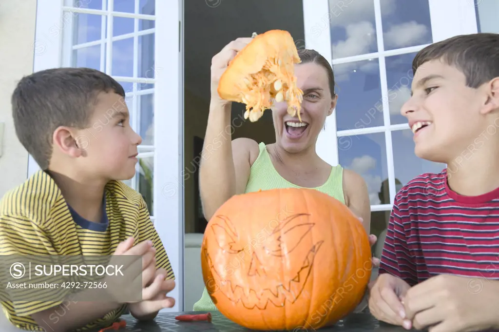 Mother and sons preparing pumpkin for halloween