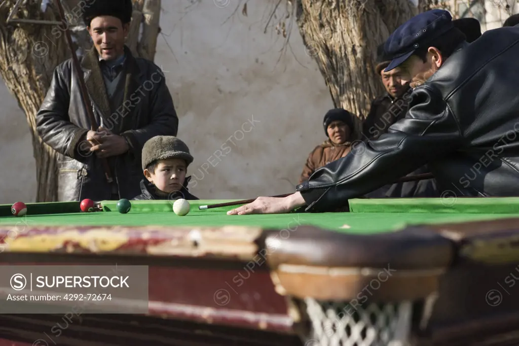 Uygur men playing billiard outdoors, Maigaiti County, Xinjiang, China