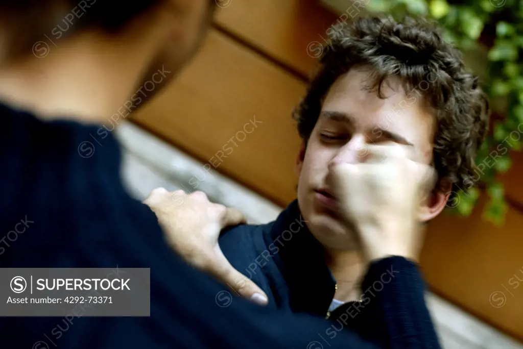 Boy punching another one in the eye
