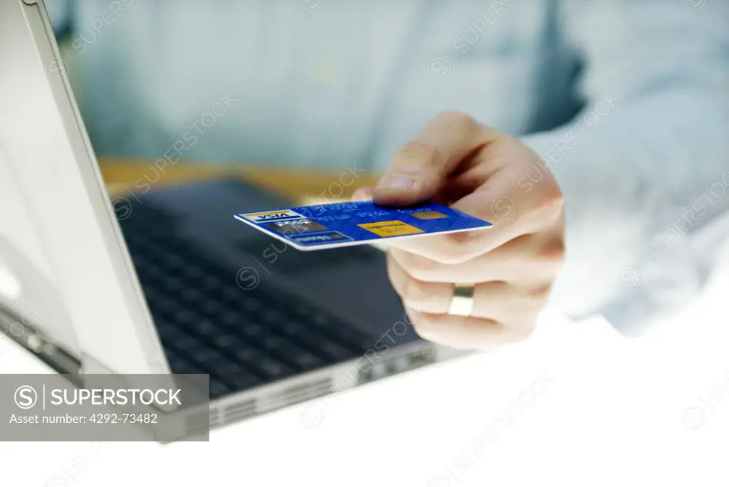 Man's hand with credit card and laptop
