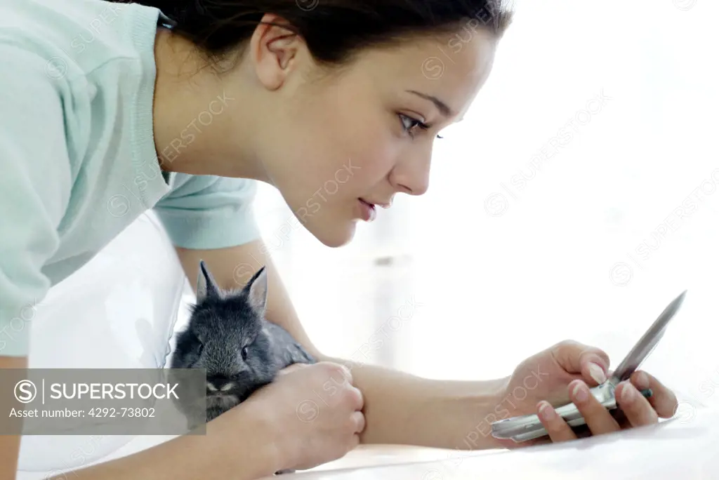 Woman sending a message and holding a rabbit