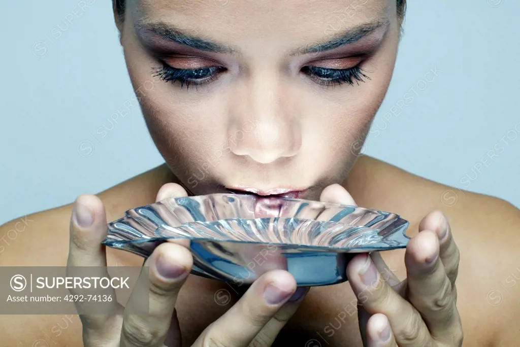 Woman drinking water from a silver cup