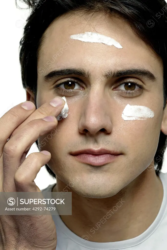 Man spreading cream on his face