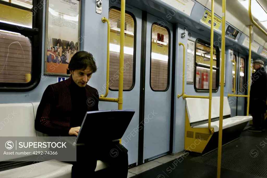 Man using laptop on subway