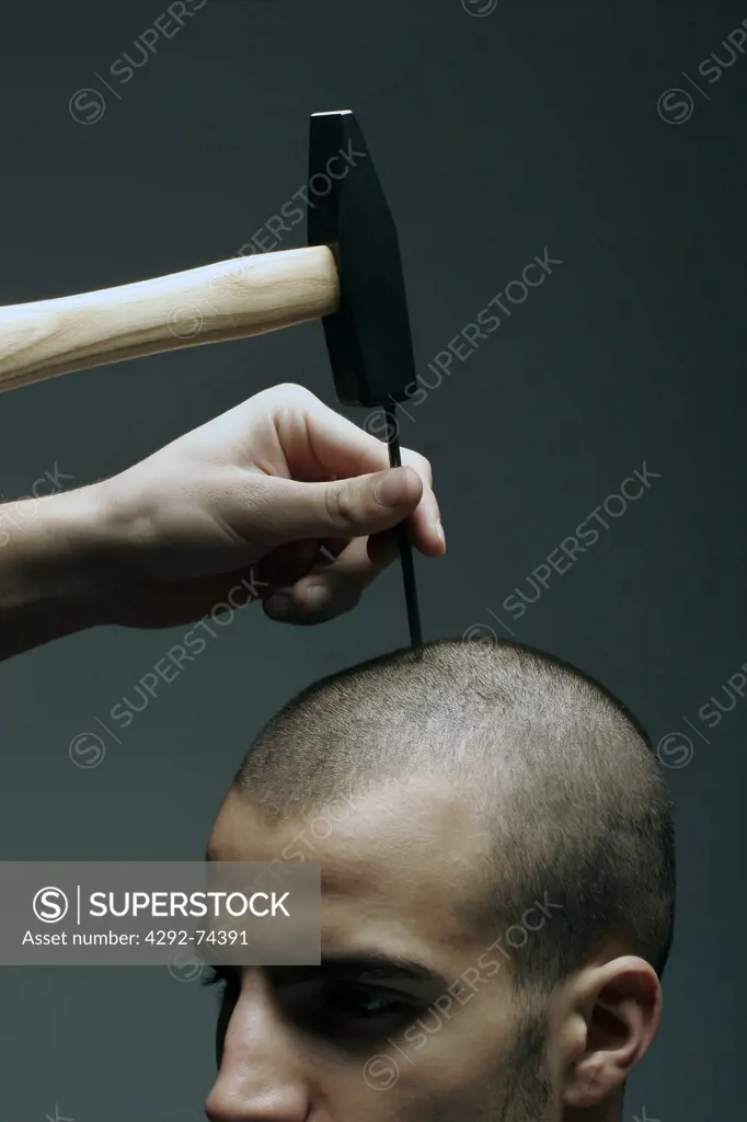 Hand about to knock a nail in man's head