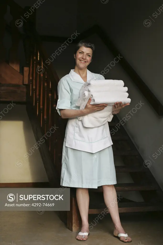 Portrait of a maid with a stack of towels