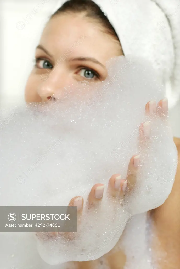 Woman in bathtub taking bubble bath