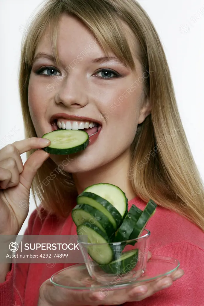 Woman's portrait eating cucumber