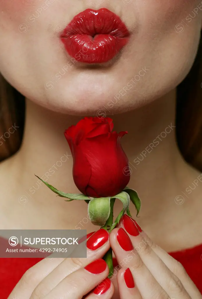 Woman holding a rose puckering lips