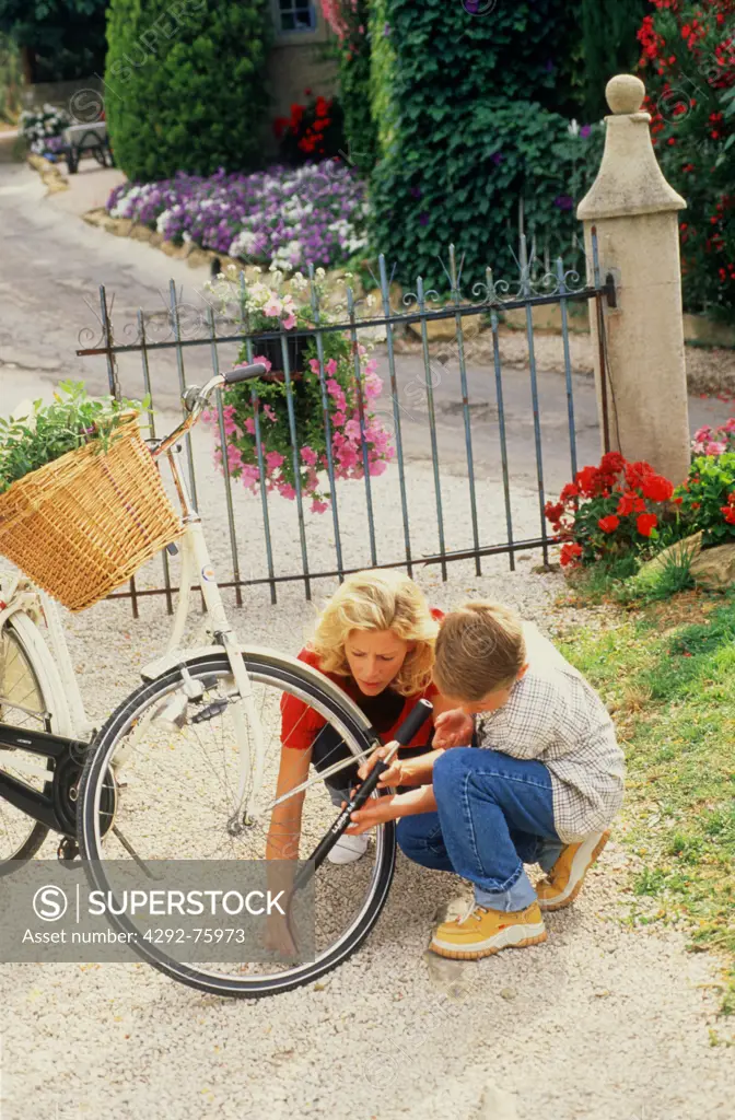 Mother and son repairing a bicycle