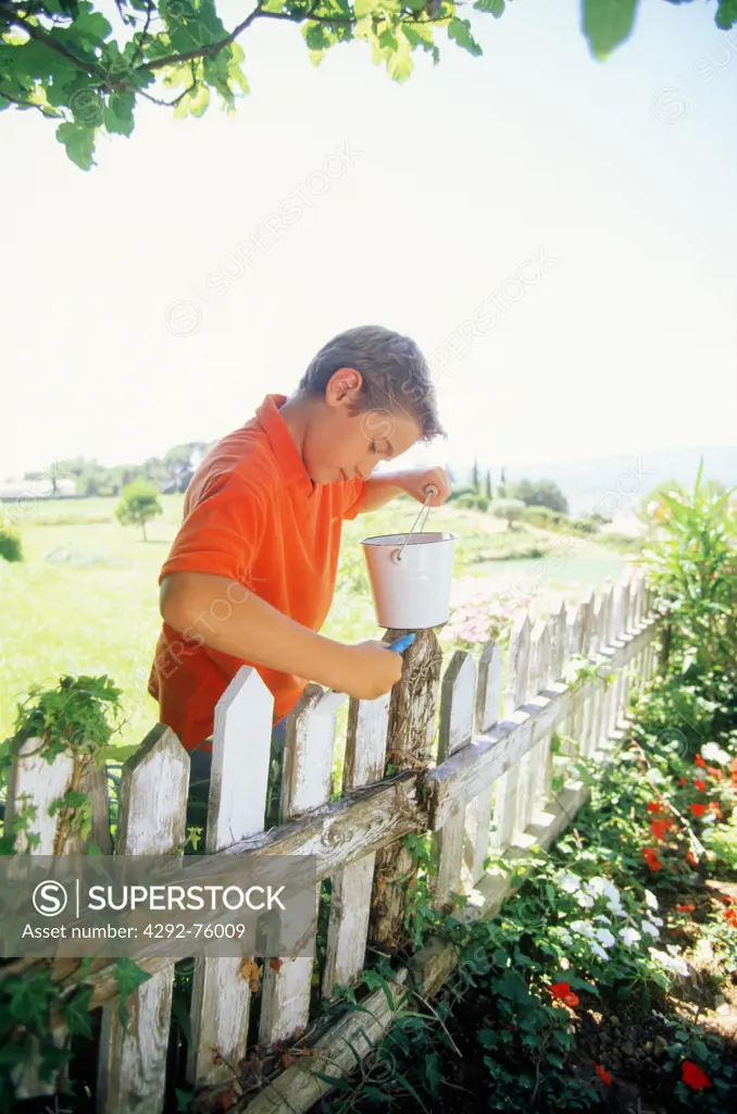 Boy painting fence