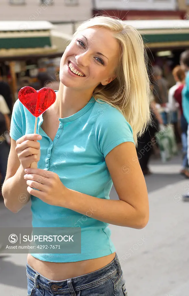 Young woman eating lollipop
