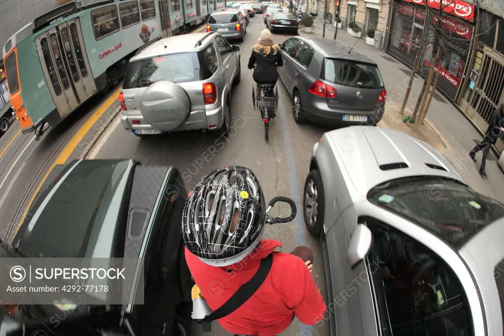 Italy, Lombardy, Milan, cyclist in traffic