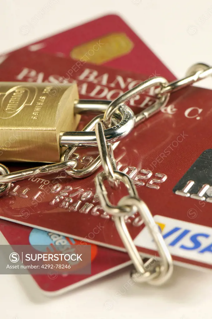 Close-up of credit cards with padlock  and chain