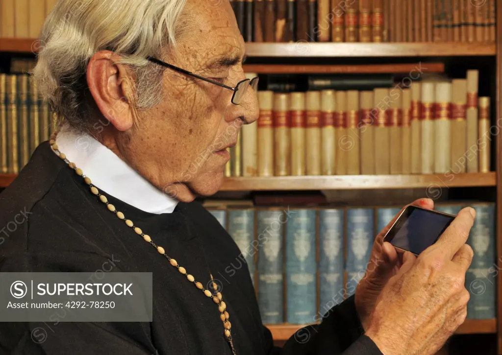 Young priest using mobile