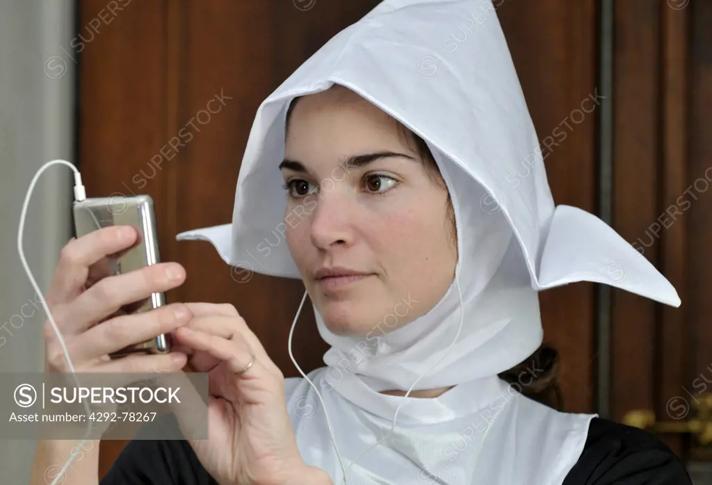 Young nun listening to music with mp3 player