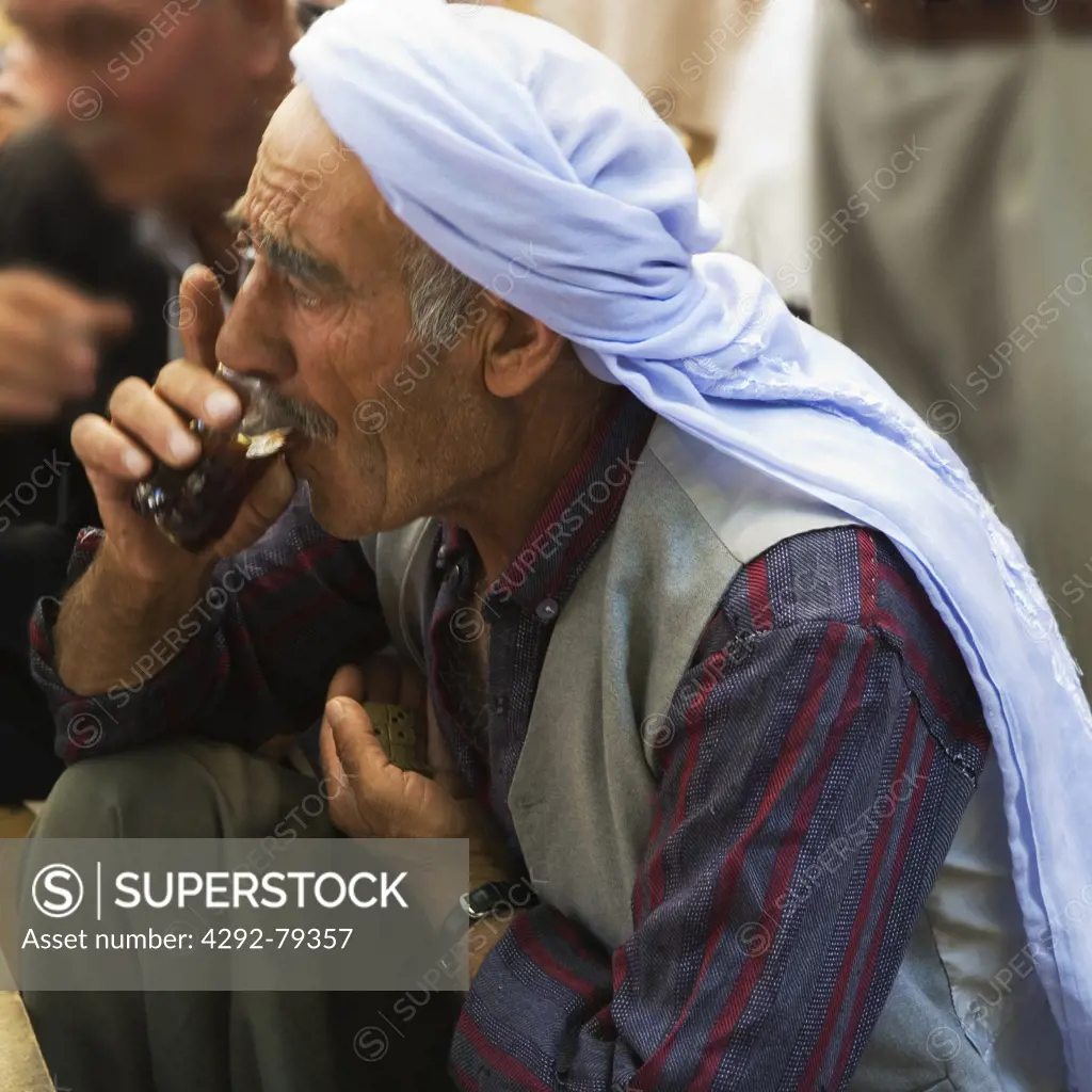Turkey, Urfa, Bazaar, in the open court of a tea house, men drnks a tea while playng domino