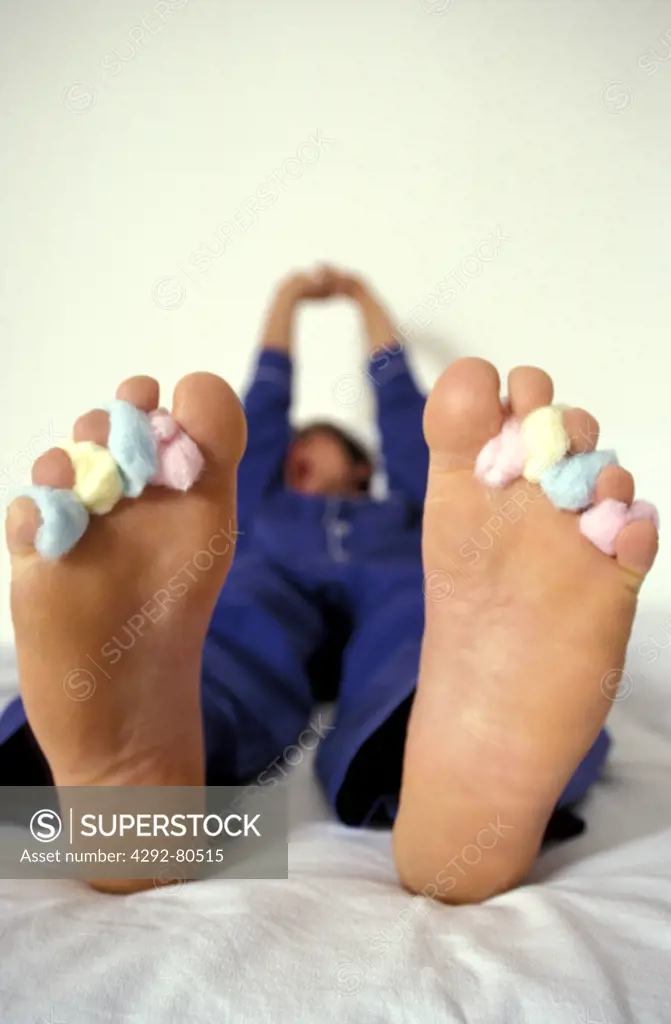 Man's feet with cotton balls between his toes
