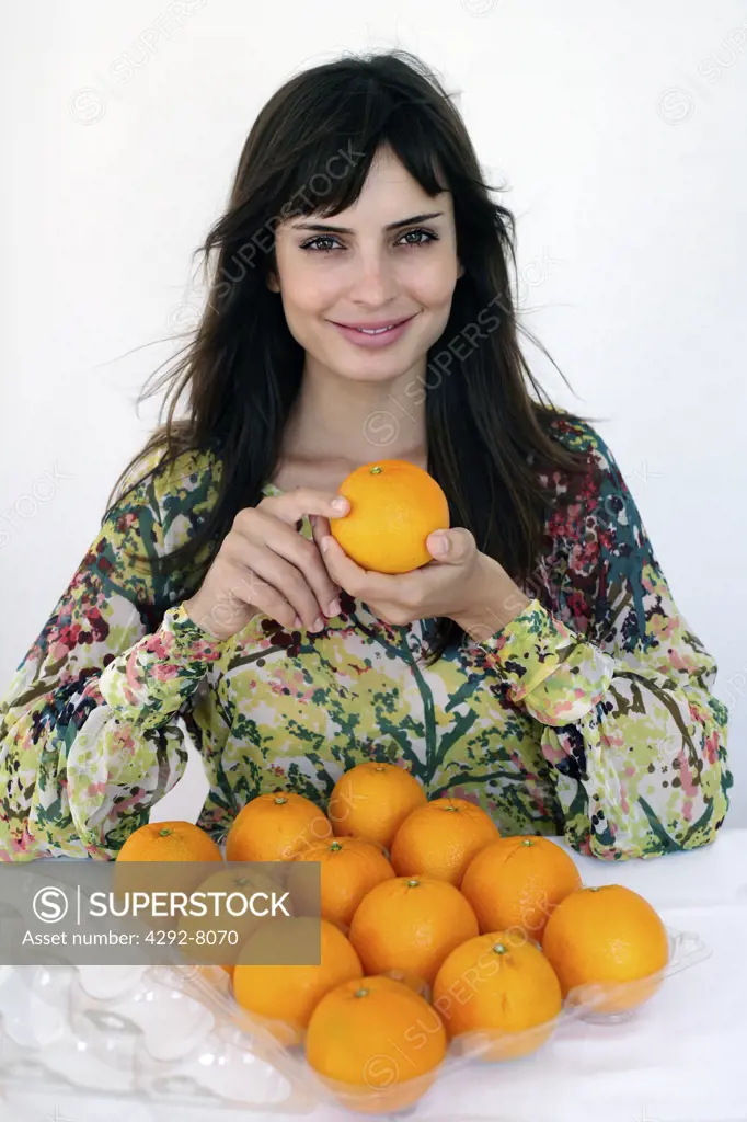 Young woman with fresh oranges