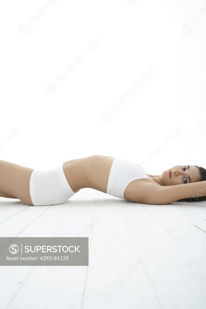 Woman in underwear lying on floor