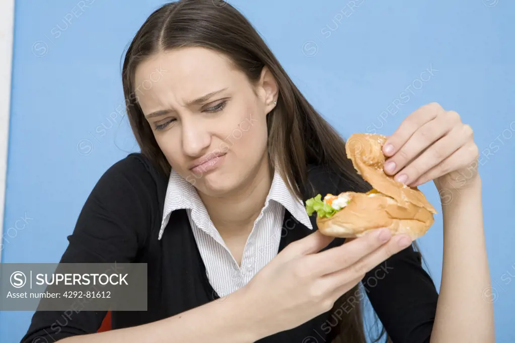 Young woman looking at hamburger