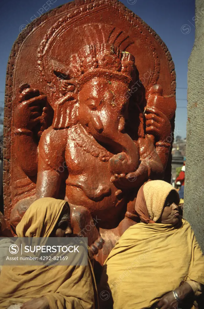 Nepal, Katmandu. Women and Ganesha statue