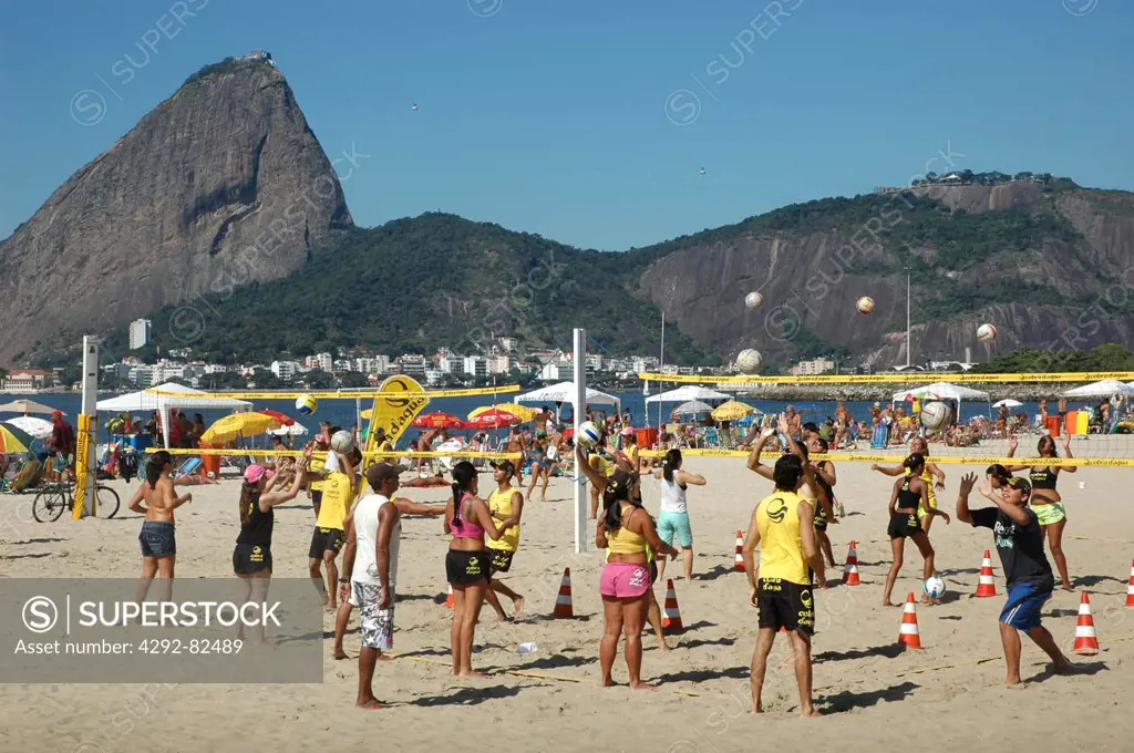 Brazil, Rio de Janeiro, Brazilians Playing Beach-volley at Praia do Flamengo the Pao de Acucar Sugar Loaf on the Background