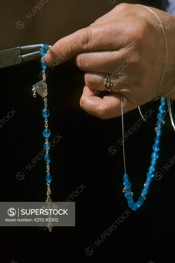 Woman's hand holding rosary