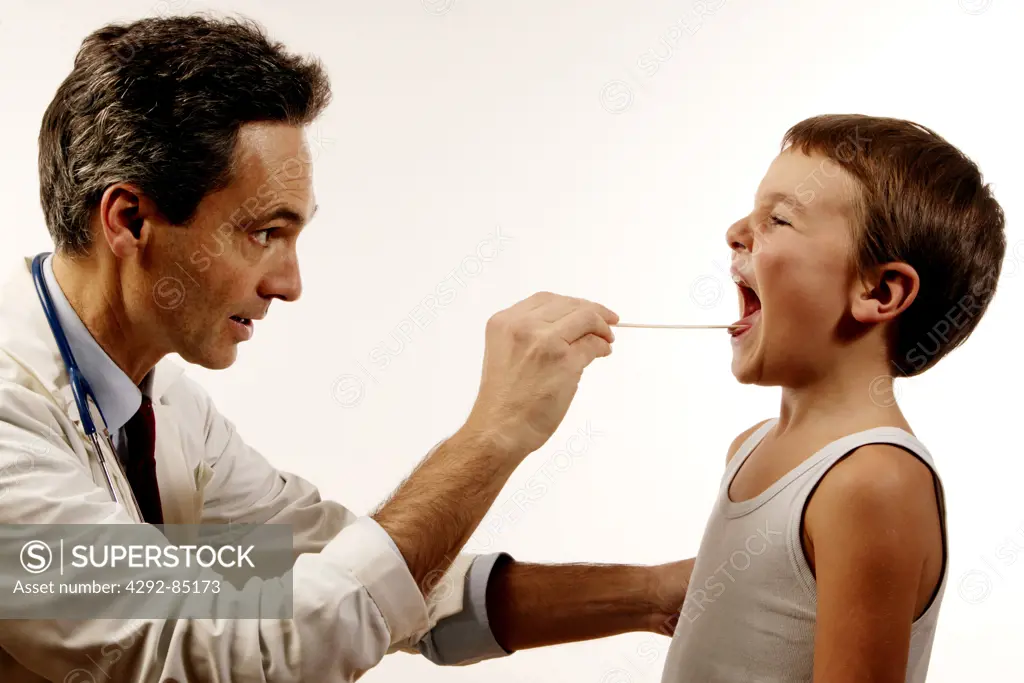 Doctor examinging boy's throat
