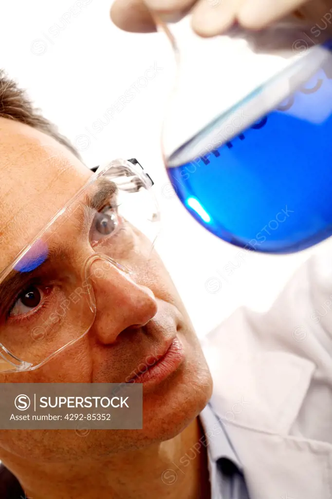 Male scientist examining beaker