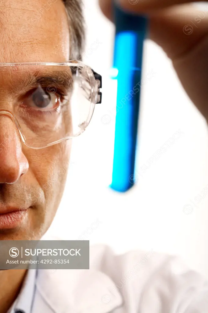 Close up of a male technician holding a vial
