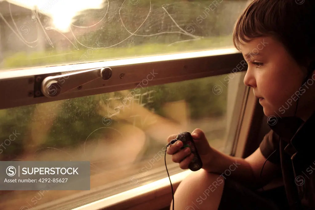 Boy sitting on train listening to music