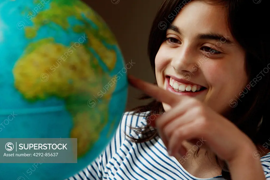 Teenage girl looking at globe