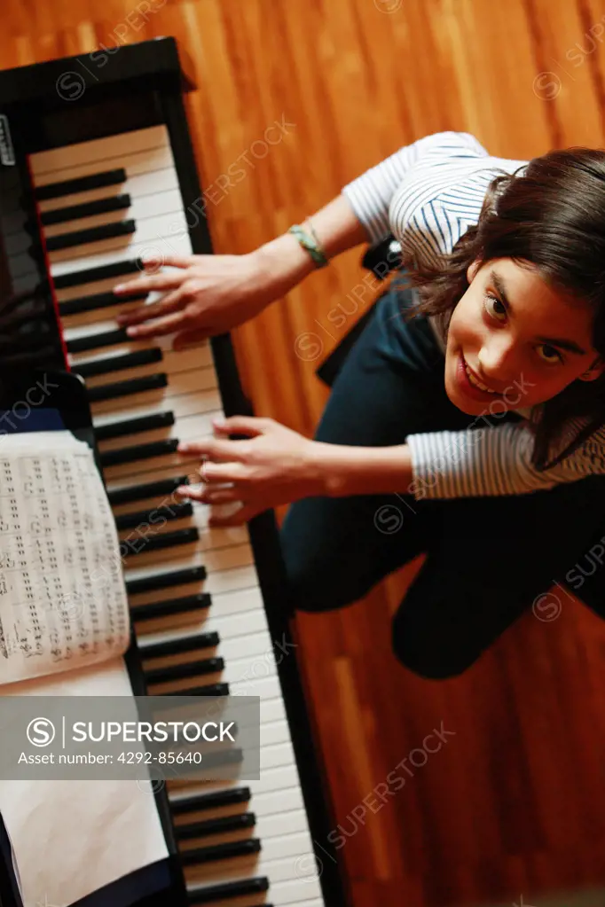 Teenage girl playing piano, hands close up