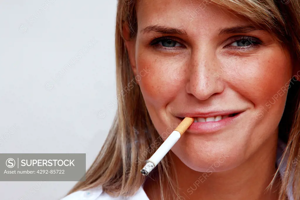 Portrait of young woman smoking close up