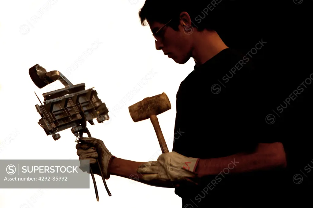 Manual worker in fabric working holding a piece of industrial fan