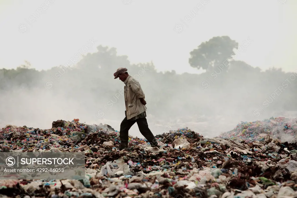 Cambodia, man walking in dump