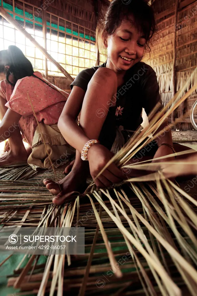 Cambodia, children aking mats