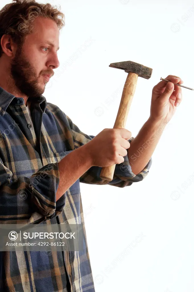 Man hammering nail into wall