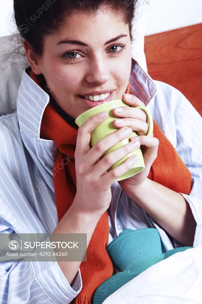 Woman in bed with hot drink